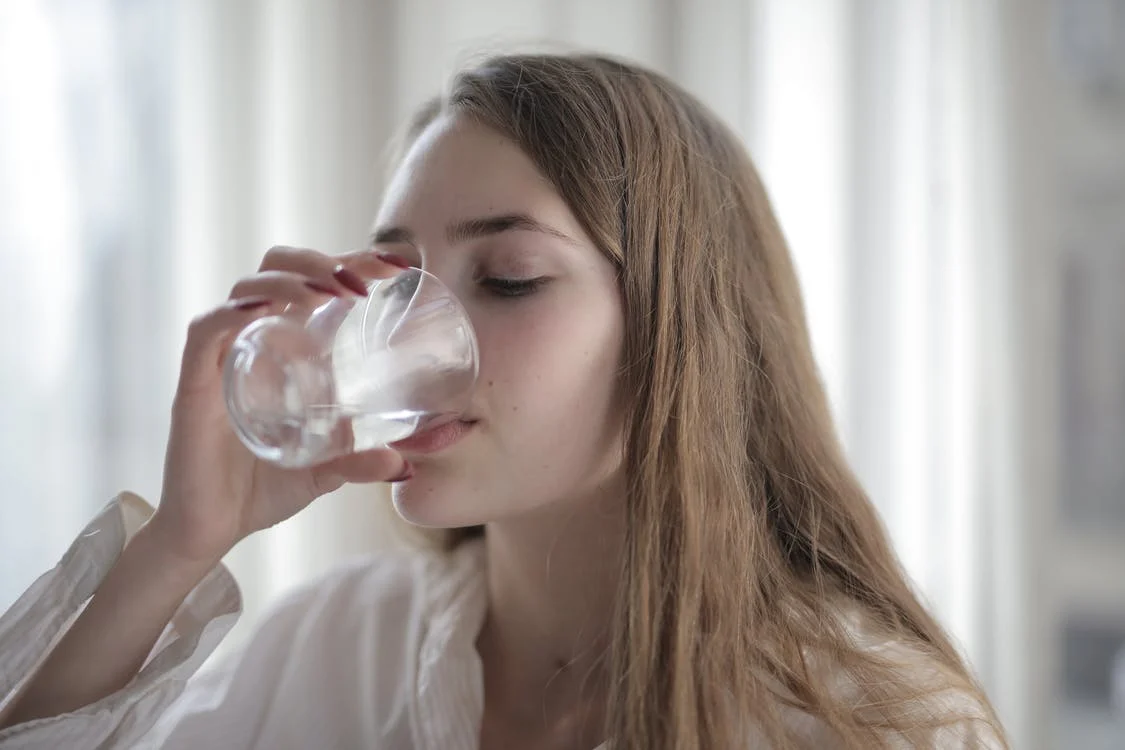 image of woman drinking water from a glass.
